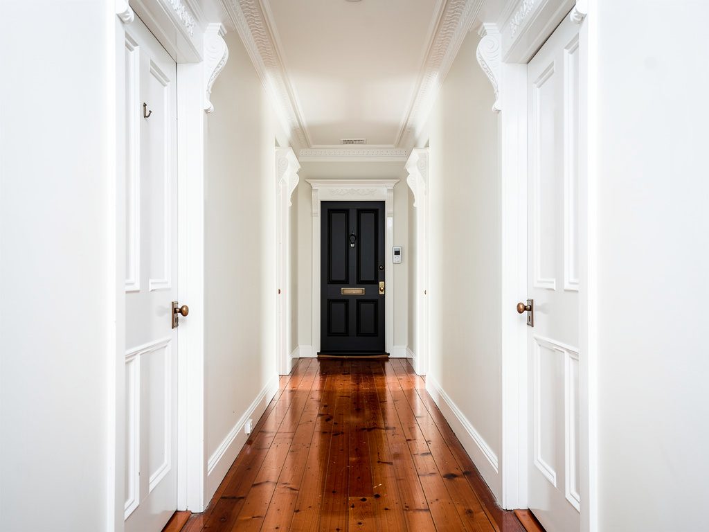 Painter scraping and preparing a weatherboard exterior in Footscray before repainting
